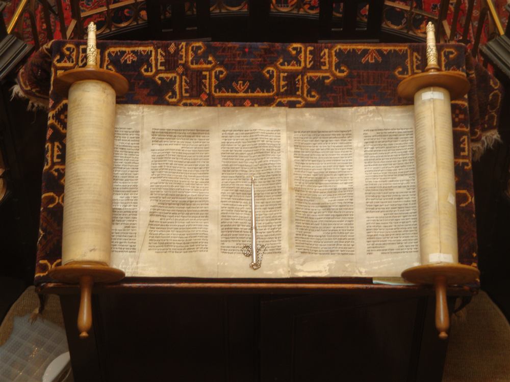 An open Torah scroll with a yad pointer