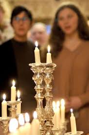 A young woman lighting Shabbat candles to mark her Bat Mitzvah