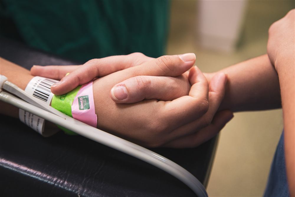 Holding hands with a hospital patient