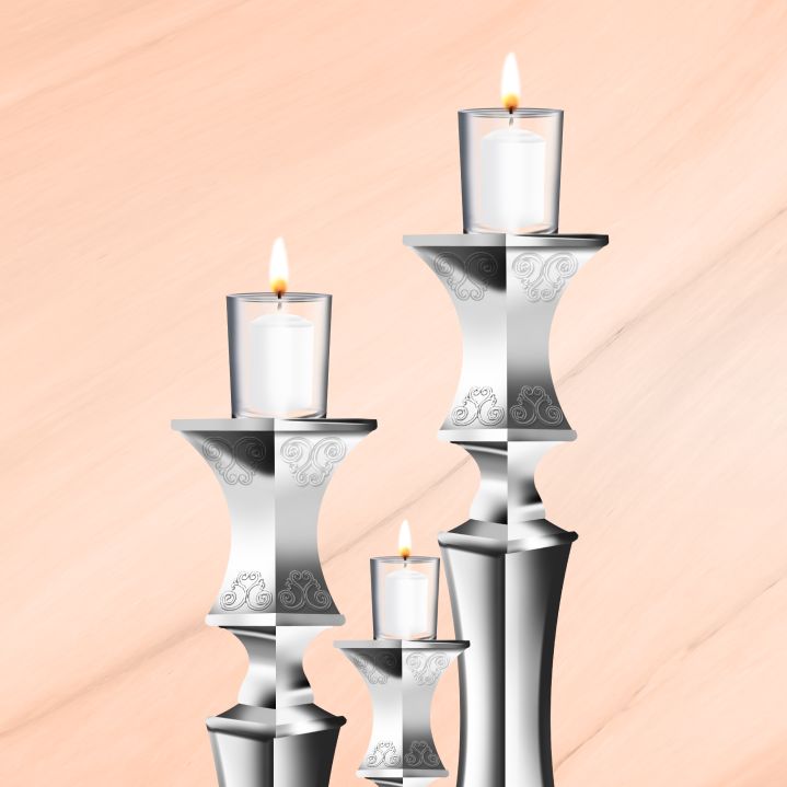 Three lit Shabbat candles of graduated sizes, two large and one smaller